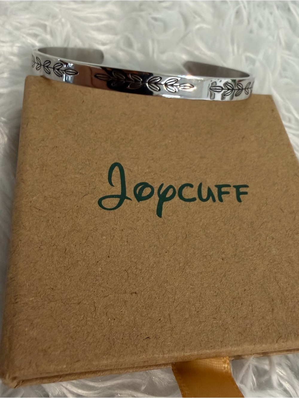 SILVER TONE CUFF BRACELET WITH ENCHANTING ENGRAVING It comes with a storage box.